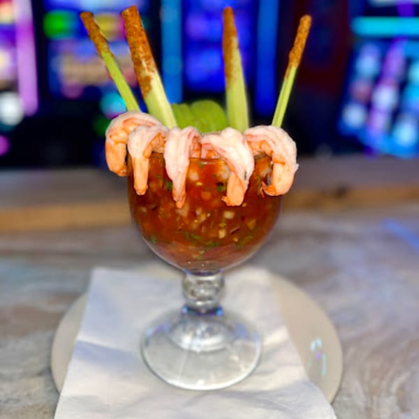 Shrimp cocktail in a goblet with celery sticks and a vibrant, colorful background at Mayan Palace.
