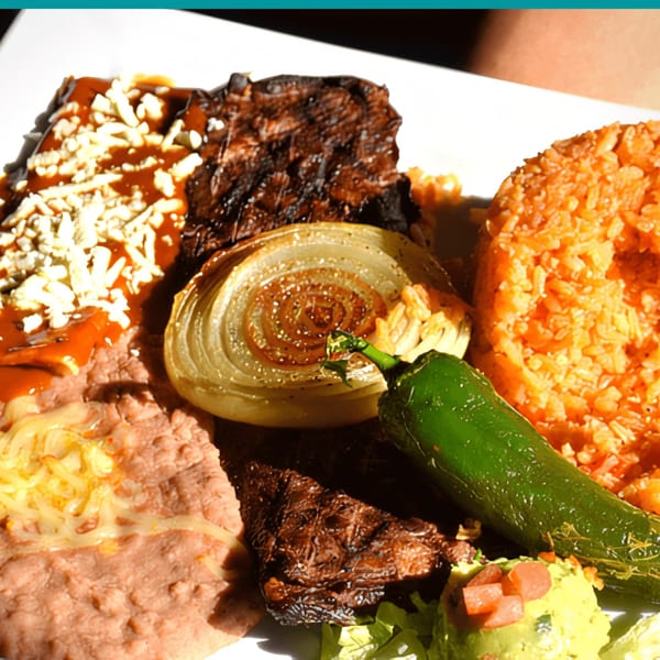 Mayan Palace's Mexican dish with grilled steak, rice, beans, onion, jalapeño, and guacamole.