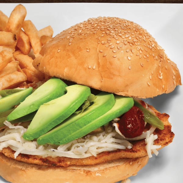 Mayan Palace Mexican torta with sliced avocado, shredded cheese, and fries on a white plate.