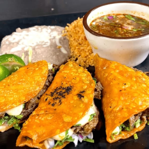 Three Mayan Palace birria tacos with rice, refried beans, and a side of consommé.