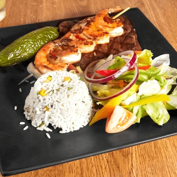 Mayan Palace's grilled shrimp skewer and steak with rice, salad, and a green pepper.