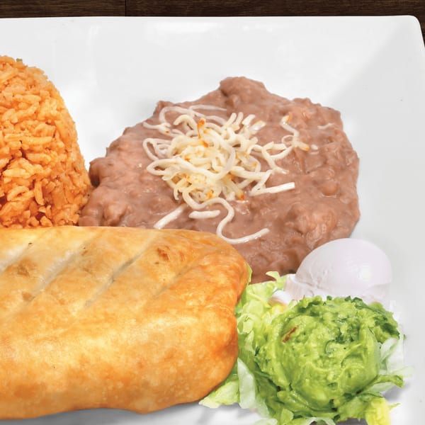 A Mayan Palace chimichanga with rice, refried beans, guacamole, sour cream, and lettuce.